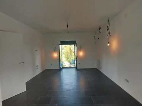 Prazna prostorija sa tamnim pločicama na podu i izlazom spolja. - image 17