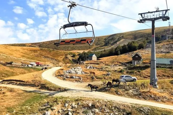 Pogled na planinski predio sa ski liftom i okolnim pejzažem.