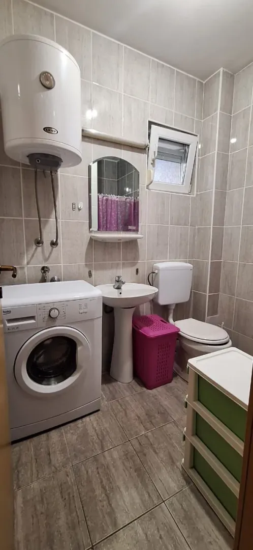 Bathroom equipped with sanitary fixtures, washing machine, and water heater.