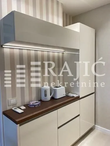 Modern kitchen with white cabinets and built-in lighting.