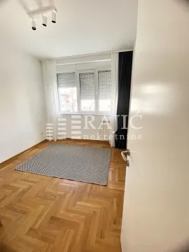 Empty room with parquet flooring and a window in an apartment. - image 11