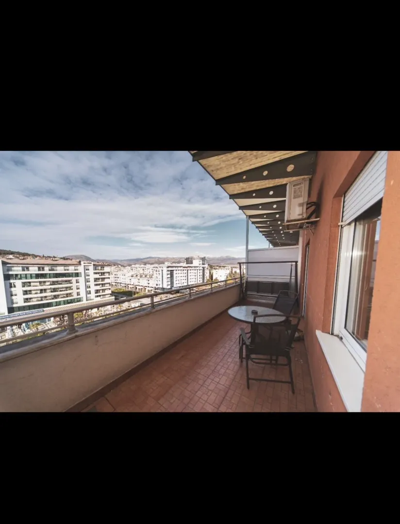Balkon sa garniturom za sjedenje i pogledom na grad.