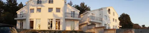 Exterior of two modern white buildings in daylight. - image 6
