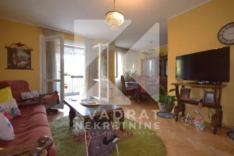 Prostrani dnevni boravak sa garniturom, televizorom i izlazom na terasu. - image 2