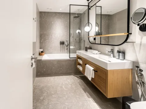 Moderne kupatilo sa kadom, staklenom tuš kabinom i drvenim ormarićem sa umivaonikom. - image 7