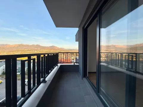 Moderan prostrani balkon sa crnom ogradom i pogledom na planine. - image 10