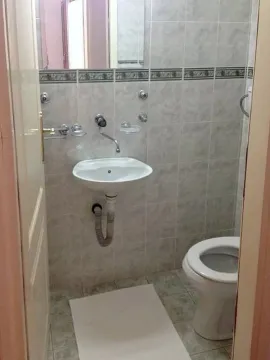 Manje kupatilo obloženo keramičkim pločicama sa umivaonikom i šoljom. - image 2