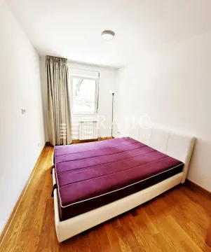 Bedroom with a double bed, wooden flooring, and a window with curtains. - image 8
