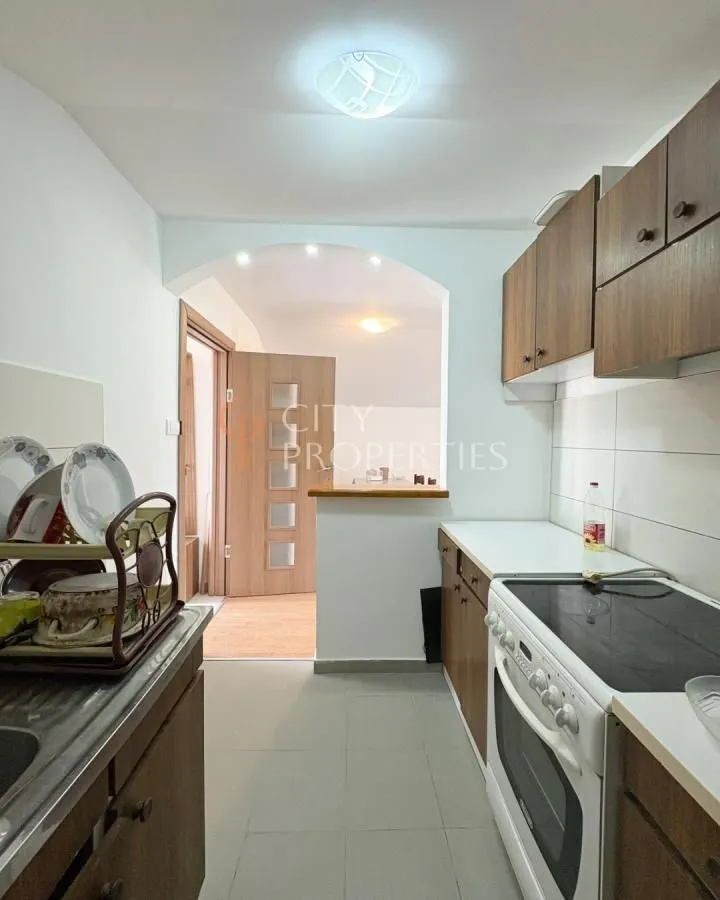 Small kitchen with wooden cabinetry and a stove.