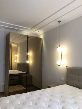 Modern bedroom featuring a large mirrored wardrobe and stylish pendant lighting. - image 5