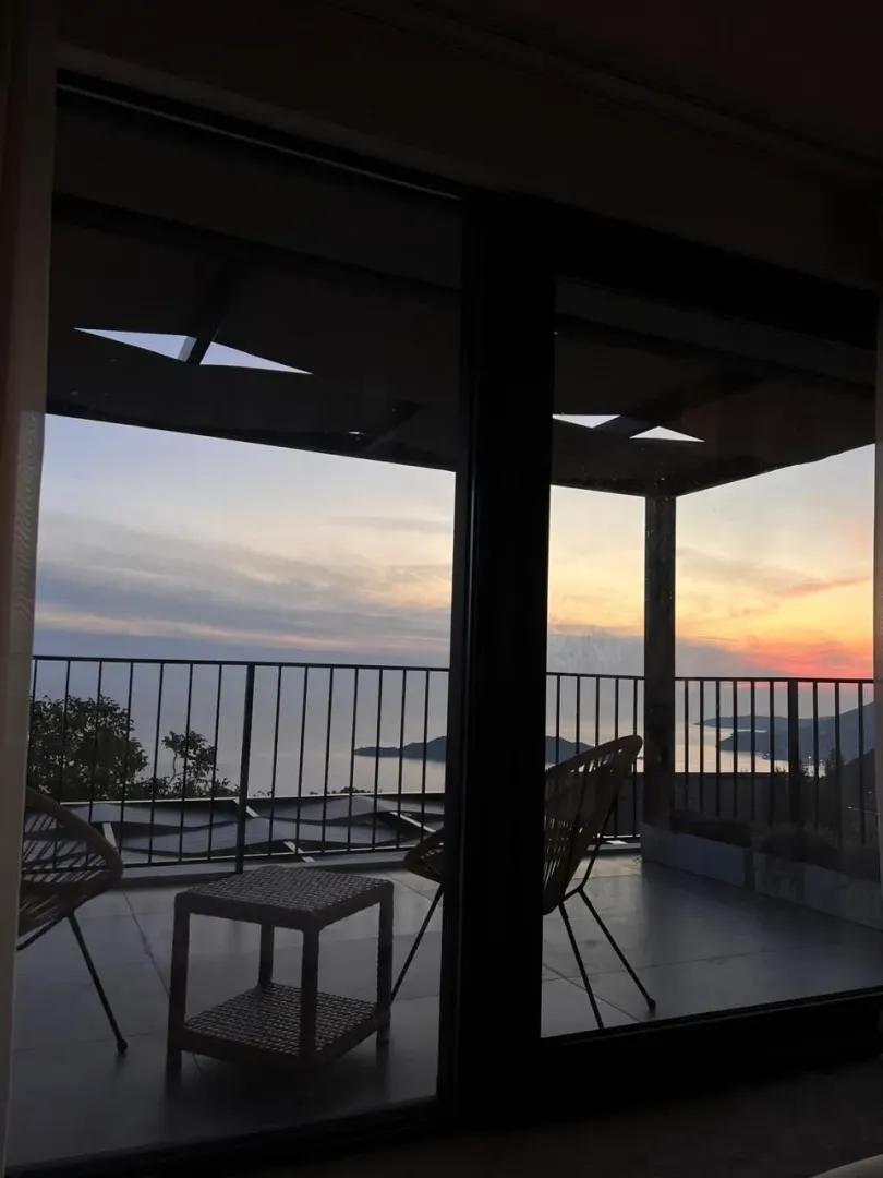 Terrace with outdoor seating and a sea view at dusk.