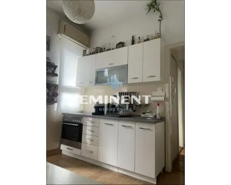Small white kitchen with upper and lower cabinets and a built-in oven. - image 7