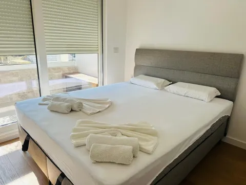 Svjetla spavaća soba sa velikim bračnim krevetom i izlazom na terasu. - image 3