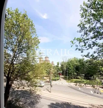 Pogled sa prozora na ulicu i park sa drvećem. - image 14