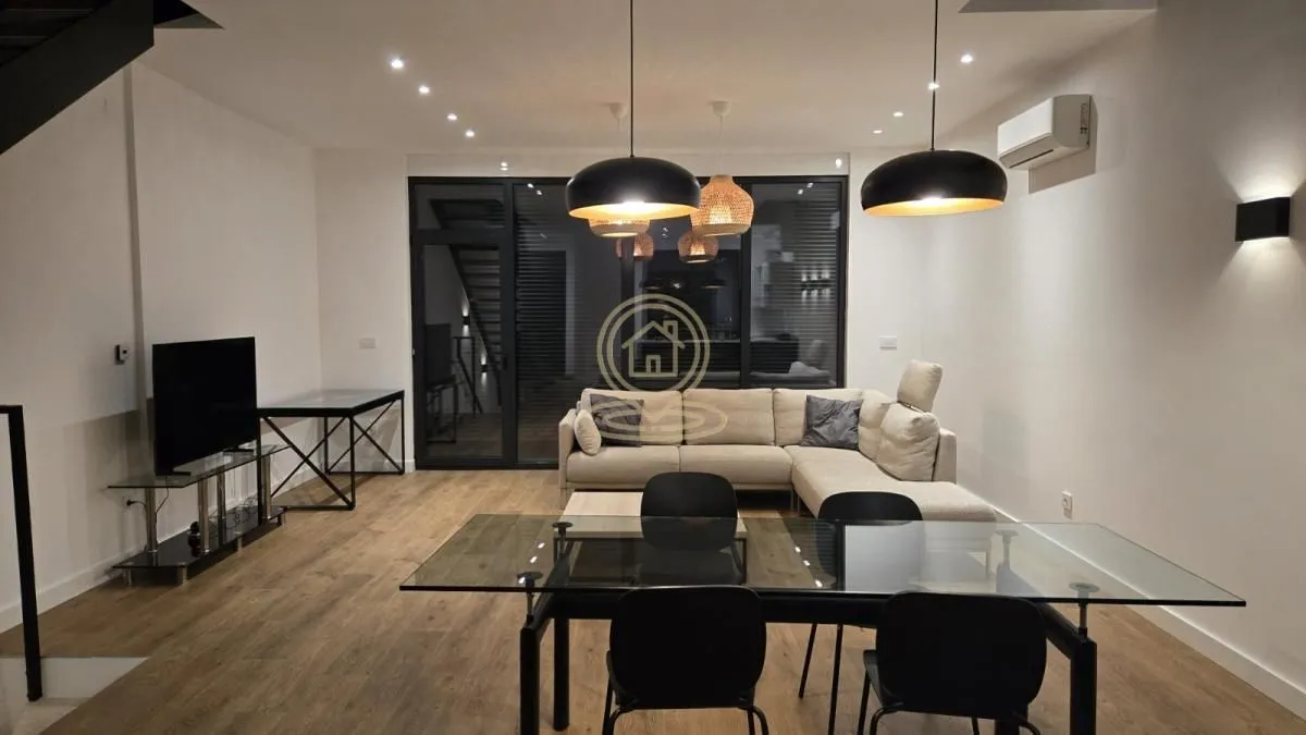 Spacious living room with a sofa set and a dining table.