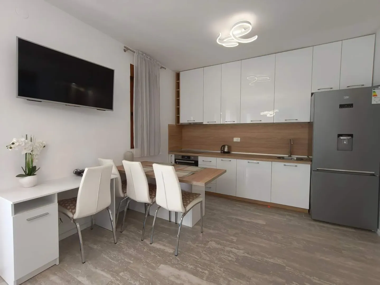 Modern kitchen with dining area and built-in appliances.