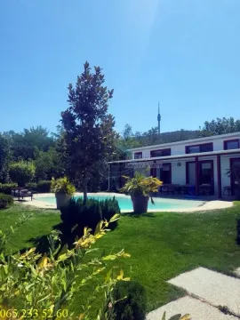 Pogled na dvorište sa bazenom i prizemnu kuću u pozadini. - image 12