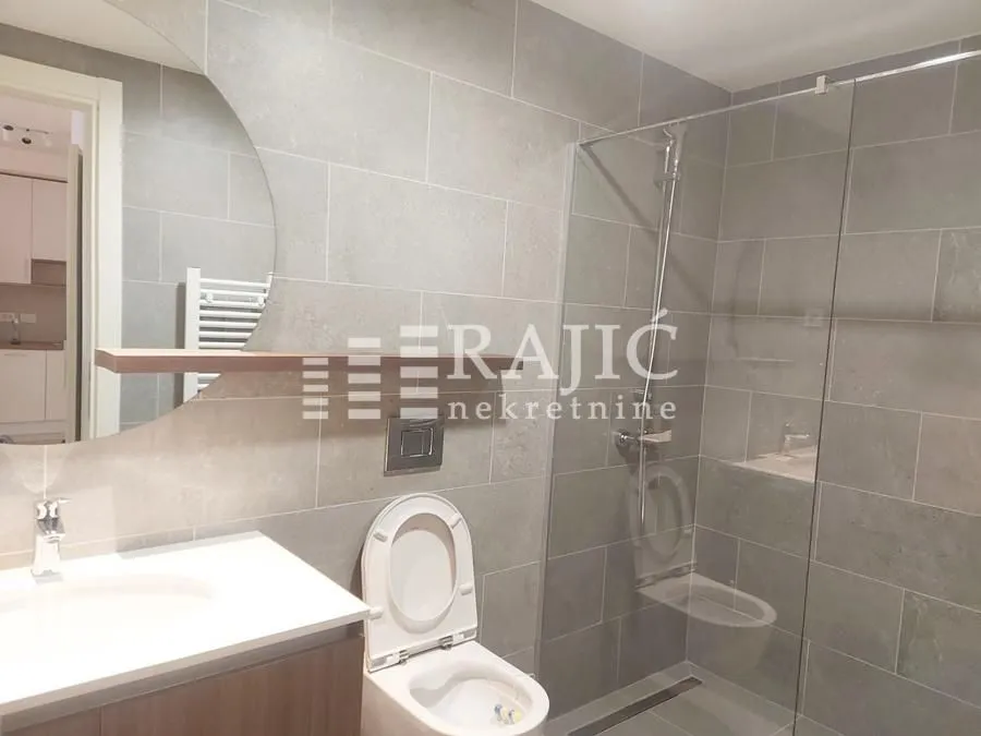 Modern bathroom with a walk-in shower and washbasin.