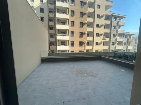 Large tiled terrace overlooking neighboring buildings. - image 12