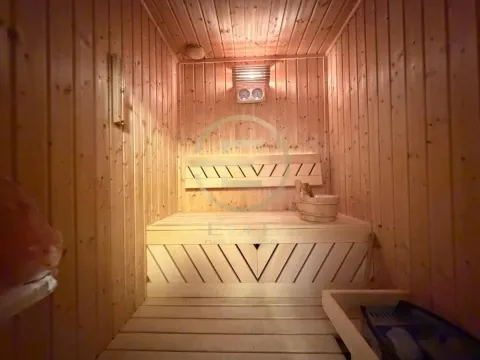 Unutrašnjost saune obložene drvetom sa klupama i peći. - image 28