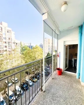 Natskriveni balkon sa pogledom na parking i zgrade u okruženju. - image 2