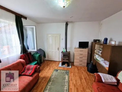 Dnevna soba sa garniturom za sedenje, peći na drva i drvenim nameštajem. - image 11