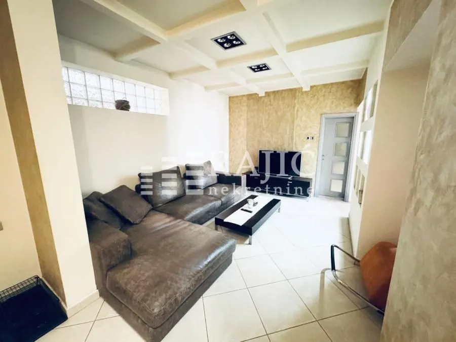 Spacious living room with a sectional sofa and modern ceiling.