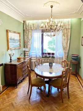 Dining room with a classic wooden table, chairs, and a sideboard. - image 2