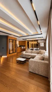 Spacious living room with a modern dropped ceiling, sofa set, and wooden flooring. - image 12
