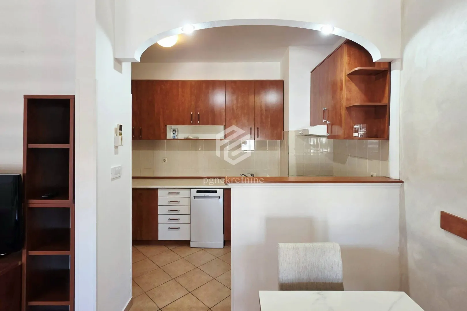 Small kitchen with wooden cabinets and appliances.