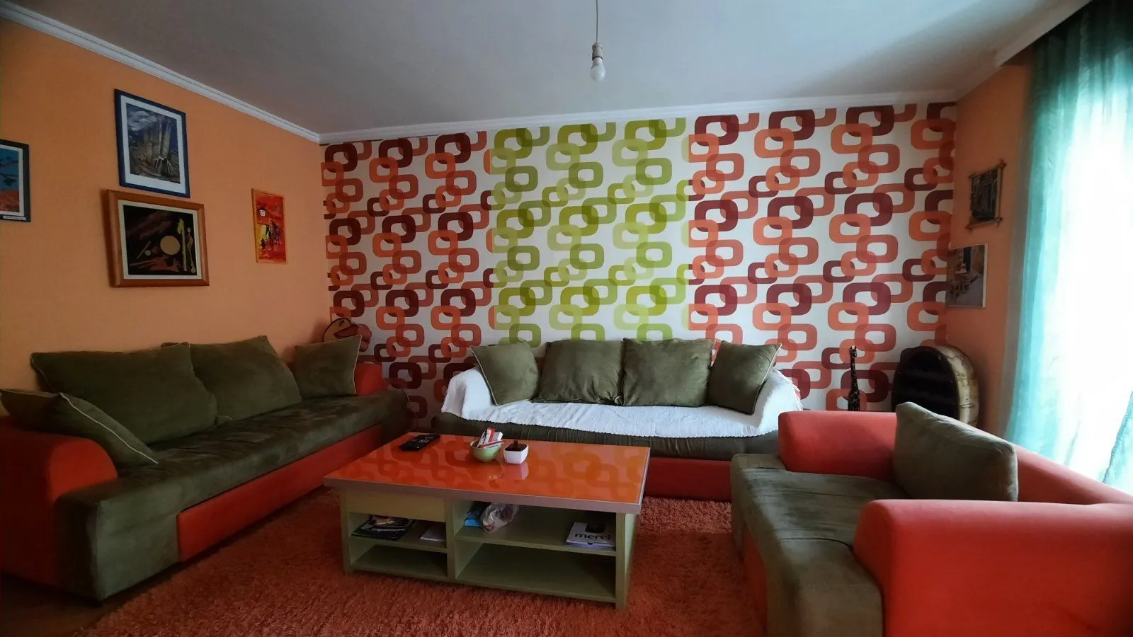 Living room with retro wallpaper, a seating set, and a coffee table.