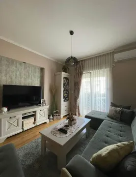 Udobna dnevna soba sa ugaonom garniturom, TV komodom i izlazom na terasu. - image 2