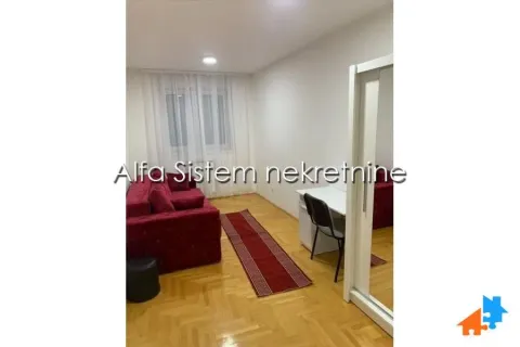 Manja dnevna soba sa crvenom garniturom, radnim stolom i parketom. - image 8