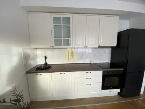 Small white kitchen with a dark countertop and a built-in oven. - image 7