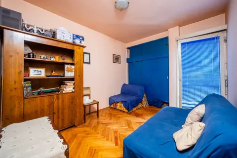 Dnevna soba sa drvenim namještajem i plavom garniturom. - image 10
