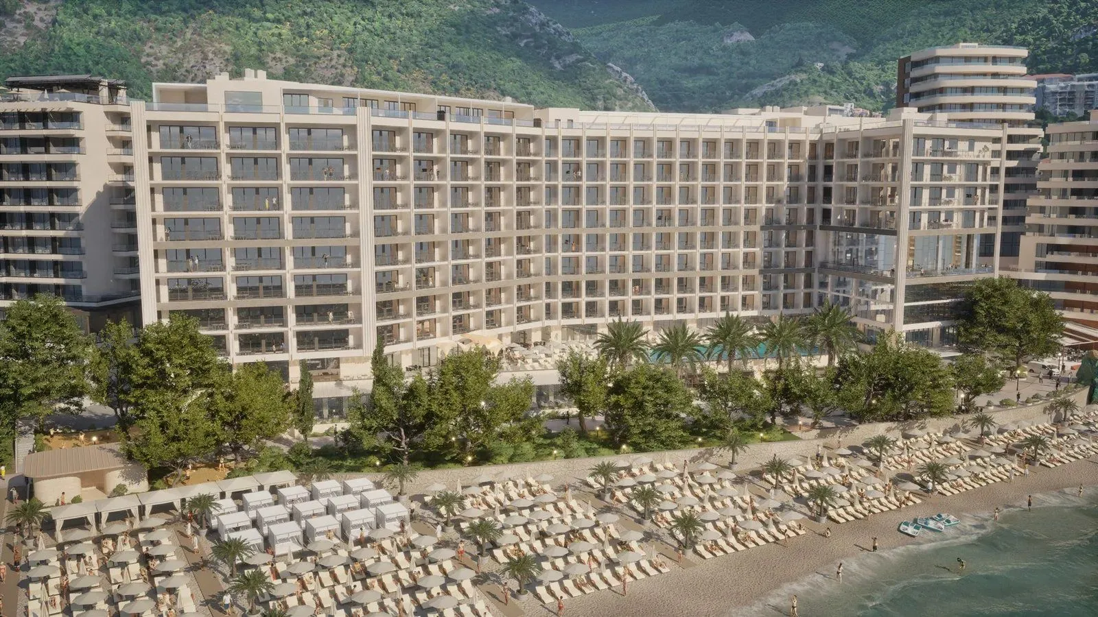 Pogled na moderan hotelski kompleks i plažu sa ležaljkama.