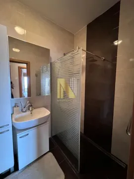 Kupatilo opremljeno umivaonikom, ogledalom i tuš kabinom. - image 7