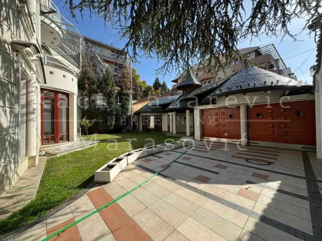 View of the landscaped courtyard with a paved area and lawn in front of the building.