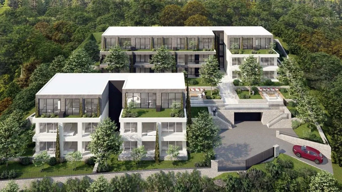 Pogled iz vazduha na kompleks modernih zgrada sa uređenim dvorištem i zelenilom.