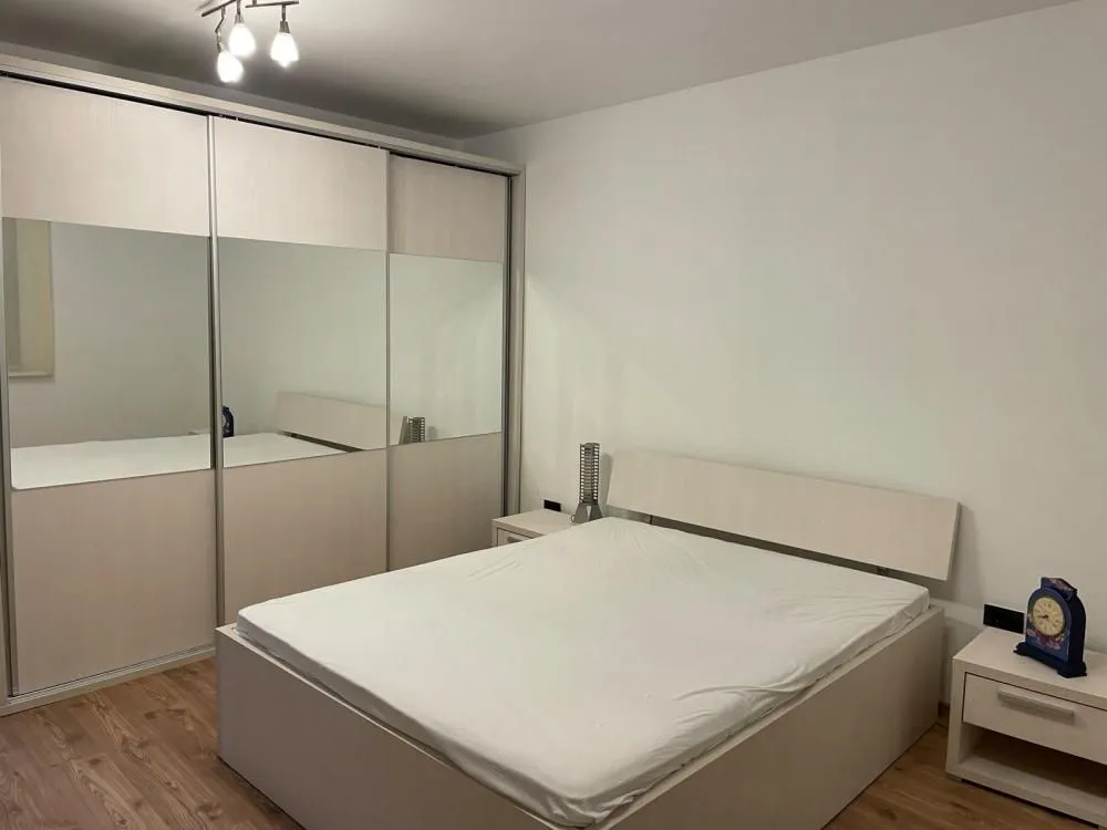 Bedroom with a double bed and a large built-in wardrobe with mirrors.