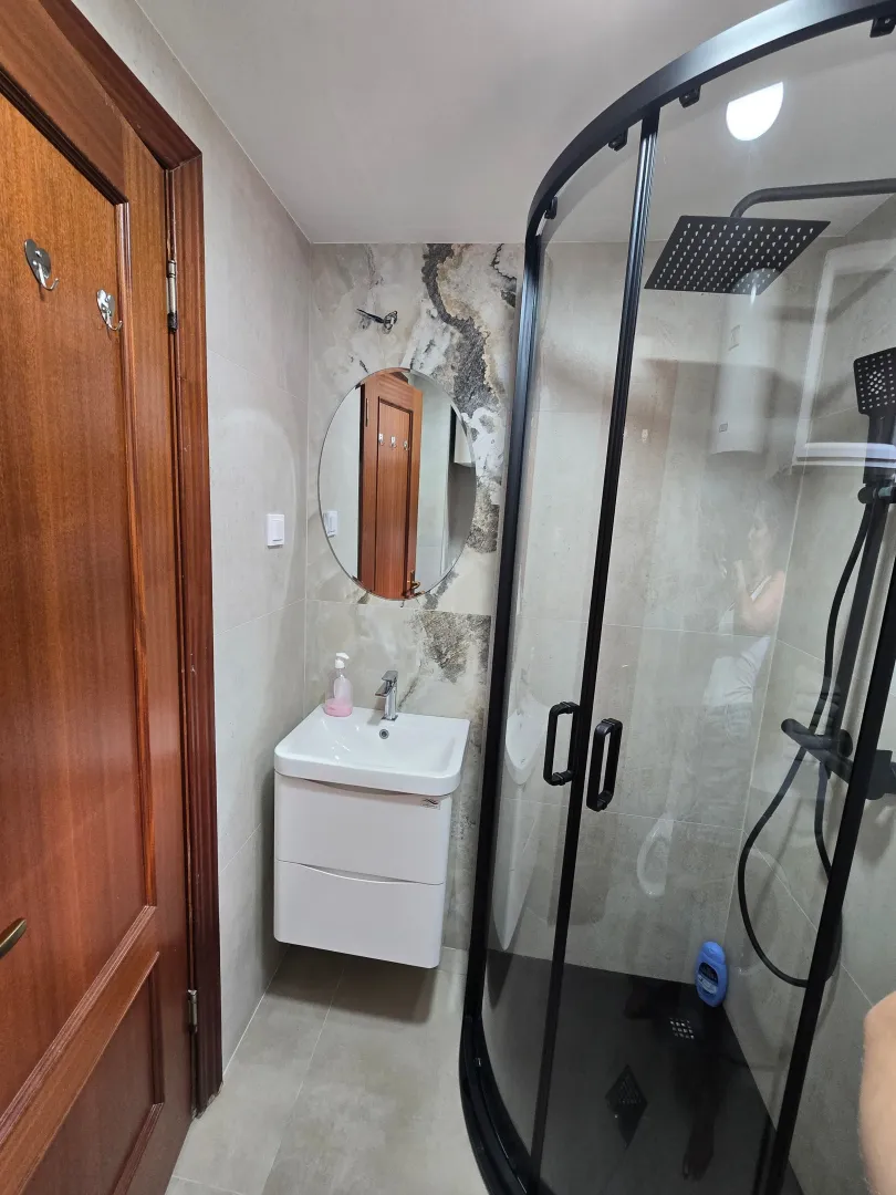 Modern bathroom equipped with a shower cabin and a sink.