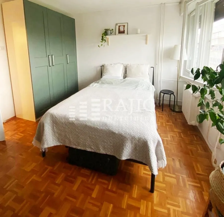 Bedroom with a double bed, wardrobe, and parquet flooring.