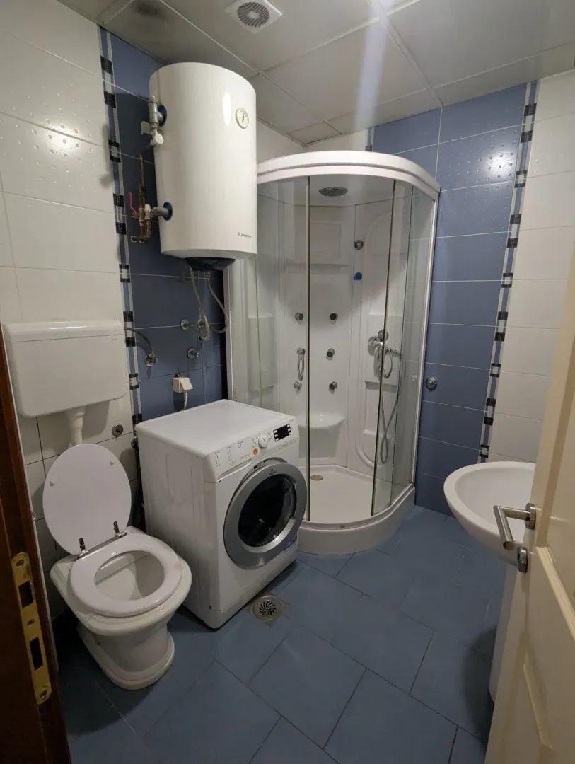 Kupatilo opremljeno tuš kabinom, WC šoljom, umivaonikom, veš mašinom i bojl.