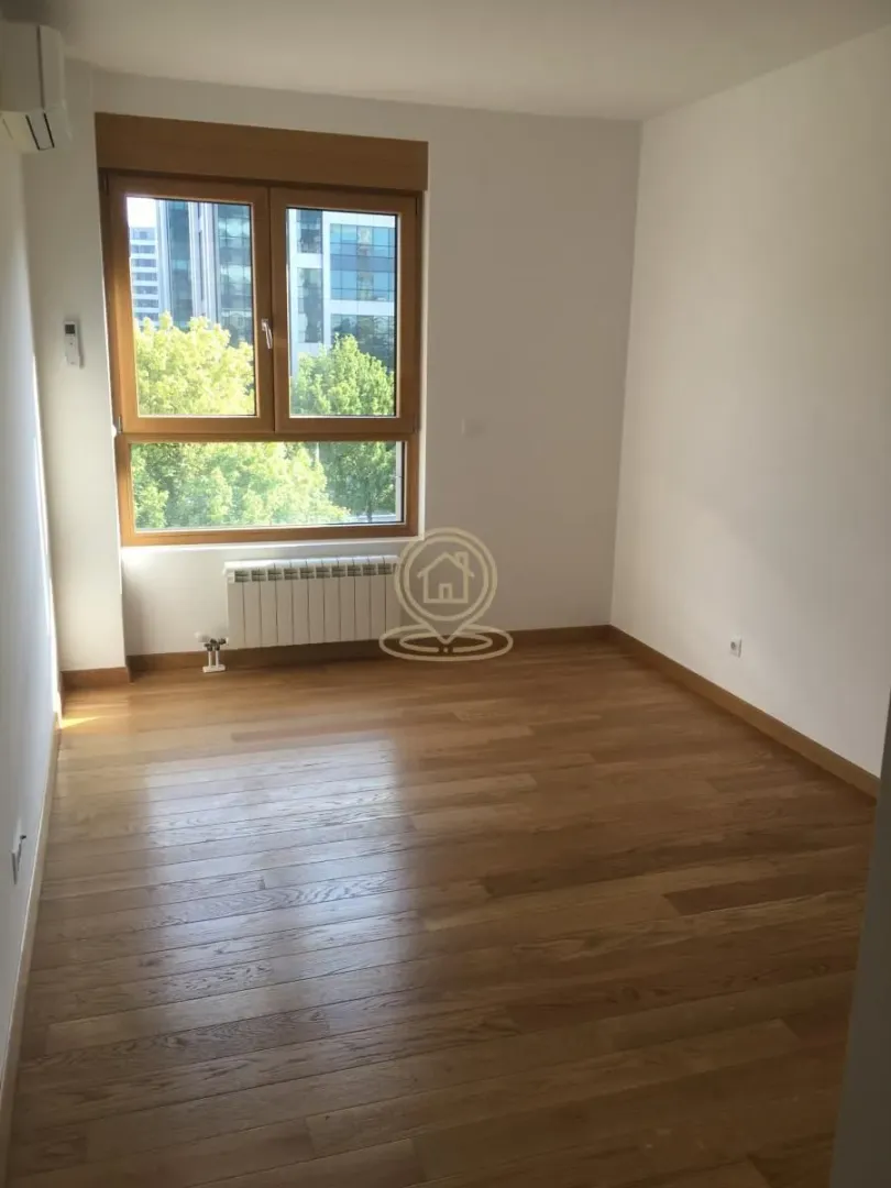 Empty room with wooden flooring and a window.