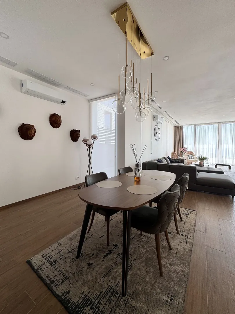 Dining area with a wooden table and chairs, connected to the living room.