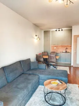 Living room with a sofa set and a dining area in the background. - image 2