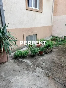Dvorište zgrade sa saksijama i zelenilom pored fasade. - image 9
