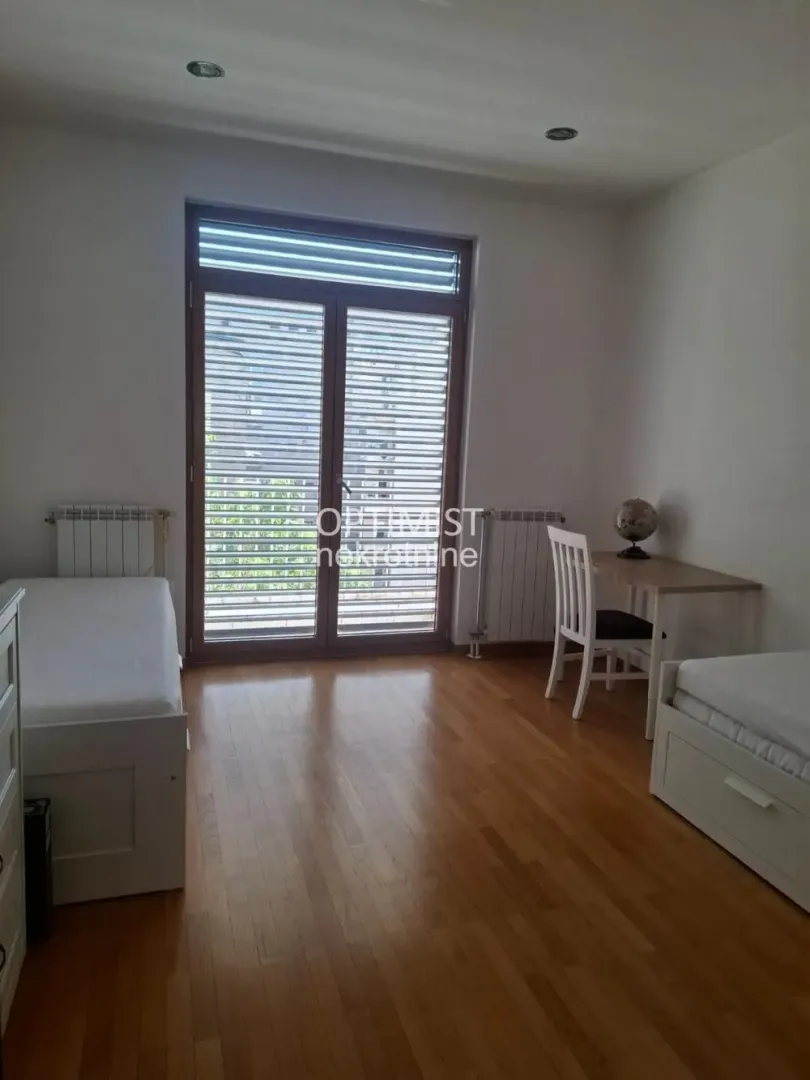 Spavaća soba sa dva kreveta i radnim stolom.