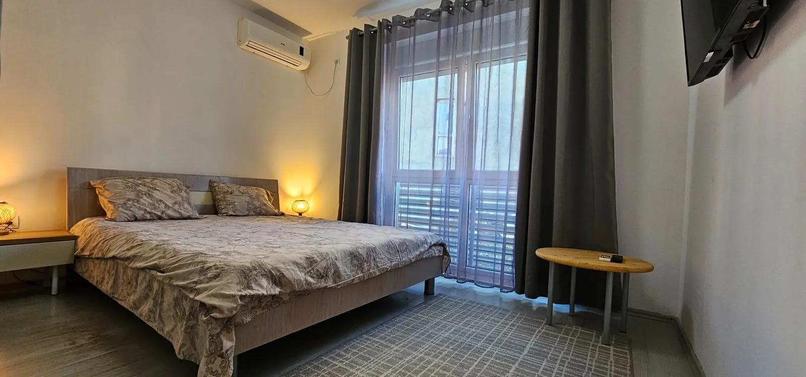 Furnished bedroom with a double bed and balcony access.