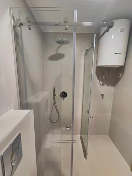 Modern bathroom with a shower cabin and water heater. - image 9